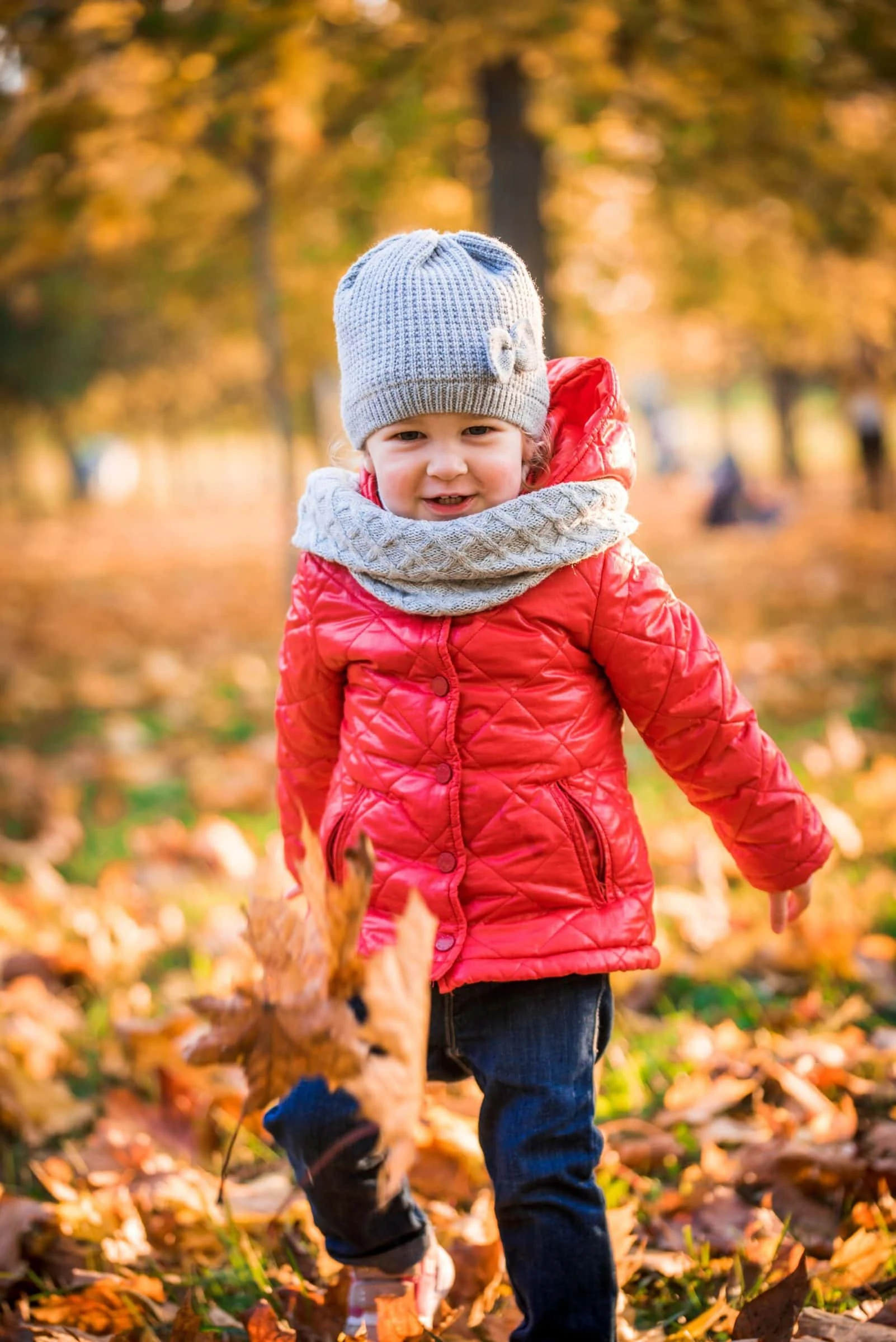 Mädchen in Herbstblättern im Wald